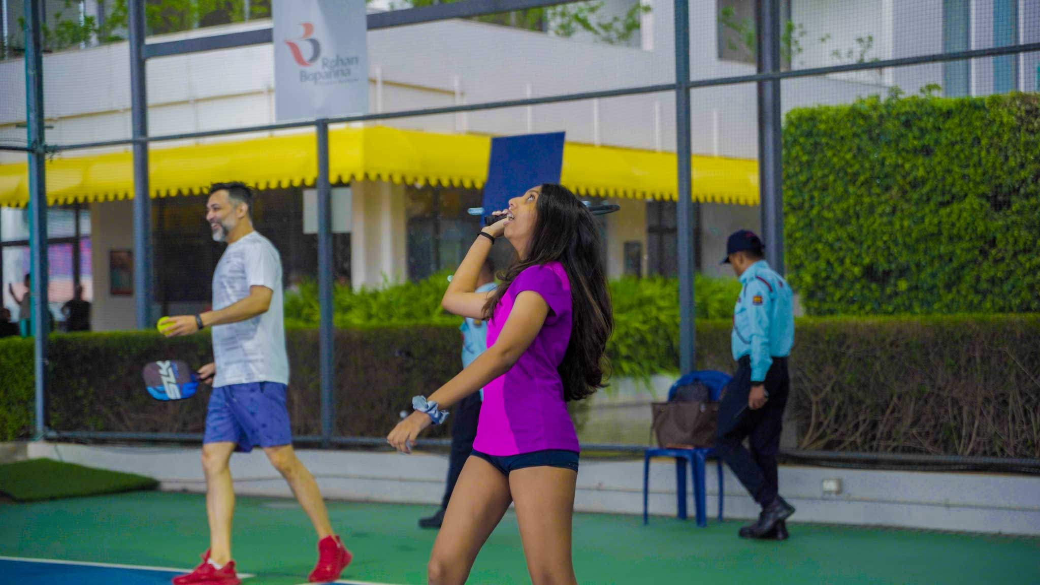 Man and woman enjoying a game of badminton together on an outdoor court in Bengaluru.